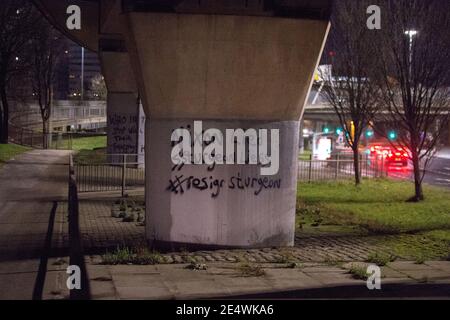 Glasgow, Écosse, Royaume-Uni. 25 janvier 2021. En photo : l'artiste de graffiti politique de Glasgow connu uniquement sous le nom de 'Clydebanksy' inspiré du nom de Banksy l'artiste, est vu peindre un slogan sur l'un des piliers du pont de Kingston qui se lit, "NIXON A MENTI SSTURGEON LIESS #RÉSIGNATION STURGEON". Il a peint dans l'AKA de Schutzstaffel le double «S» dans les mots «turgeon» et le mot «mensonges» pour faire un point sur la façon dont il pense que le SNP est en train de diriger le pays. Crédit : Colin Fisher/Alay Live News Banque D'Images