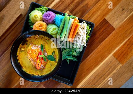 Cuisine thaïlandaise délicieuse et belle nourriture / nouilles de riz colorées ou riz thaïlandais vermicelles nouilles et poisson crabe curry sauce soupe avec légumes sur plaque WO Banque D'Images