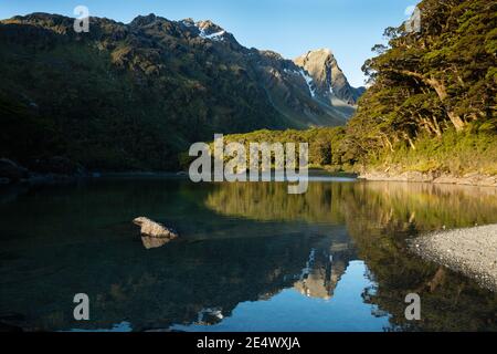 Les montagnes se reflètent dans les eaux claires du lac Mackenzie, Routeburn Track, Nouvelle-Zélande Banque D'Images