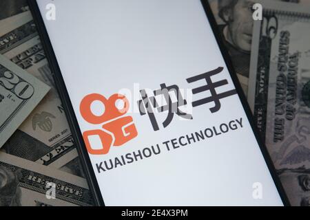 Stafford, Royaume-Uni - janvier 25 2021 : logo de l'application Kuaishou visible sur l'écran du smartphone et billets en dollars flous en arrière-plan. Concept de Banque D'Images