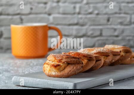 Petits gâteaux faits maison avec fromage cottage et une tasse de thé sur fond gris. Cuisson maison Banque D'Images