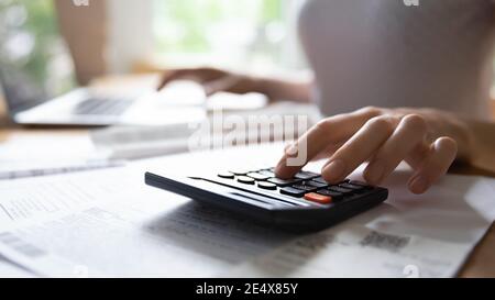 Les jeunes femmes comptent sur la calculatrice électronique planifiant le budget familial Banque D'Images