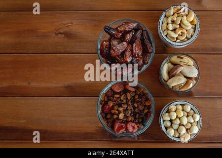 Assortiment de noix et de fruits secs sur une table en bois, vue sur le dessus. Vue de dessus. Bols avec en-cas santé Banque D'Images