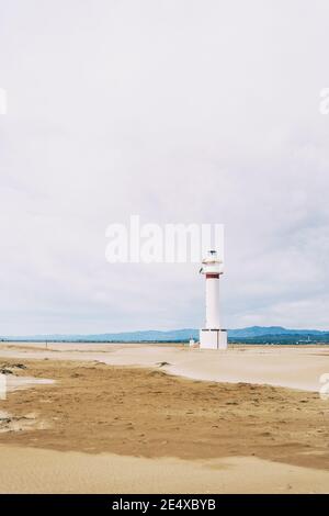 phare sur la plage solitaire du delta de l'ebro, tarragone, espagne. La journée est nuageux et venteuse. Banque D'Images