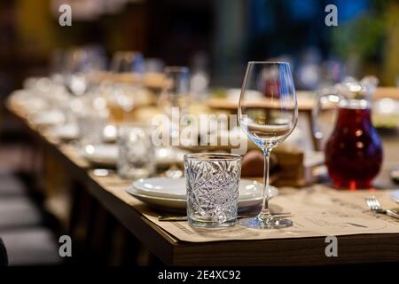 Tables disposées pour un événement ou une réception de mariage. dîner élégant et luxueux dans un restaurant. Verres et plats. Les verres vides sont mis dans le support Banque D'Images