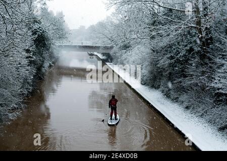 Une personne paddle-board sur le Grand Union Canal par temps enneigé, Warwick, Warwickshire, Royaume-Uni Banque D'Images