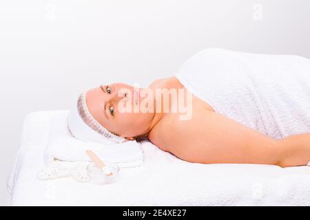 Photo agrandie. L'esthéticienne applique un masque hydratant au visage d'une femme plus âgée avec une brosse. Banque D'Images