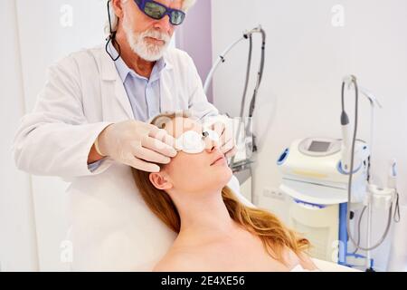 Dermatologue préparant la thérapie laser Fraxel pour le renouvellement de la peau sur le face Banque D'Images