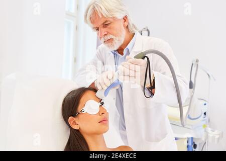 Chirurgien esthétique spécialisé dans le traitement au laser sur le front d'un patient Banque D'Images