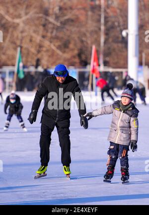 (210125) -- HULUNBUIR, le 25 janvier 2021 (Xinhua) -- Wang Quanli (L) patins portant une nouvelle paire de patins à glace sur une patinoire de Yakeshi de Hulun Buir, dans la région autonome de la Mongolie intérieure, au nord de la Chine, le 21 janvier 2021. Wang Quanli, 65 ans, qui a perdu ses jambes lors d'un accident il y a 35 ans, a commencé à patiner en 2019 et est rapidement devenu un passionné de ce sport. Après des années de pratique, il est maintenant un patineur qualifié avec des membres artificiels. (Xinhua/Lian Zhen) Banque D'Images