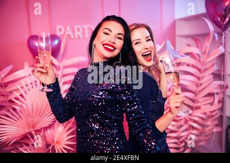 Des femmes gaies tenant des verres à champagne dans leurs mains Banque D'Images