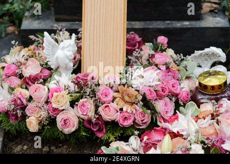 couronne funéraire avec des roses et un ange sur une tombe après un enterrement Banque D'Images