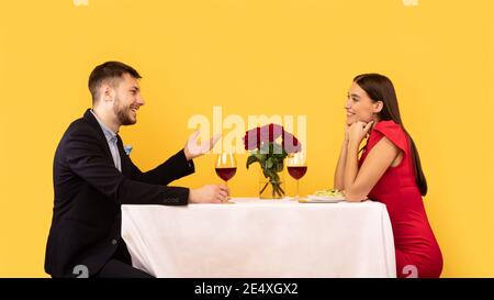 Petite amie et Boyfriend qui parlent d'avoir une date romantique sur fond jaune Banque D'Images