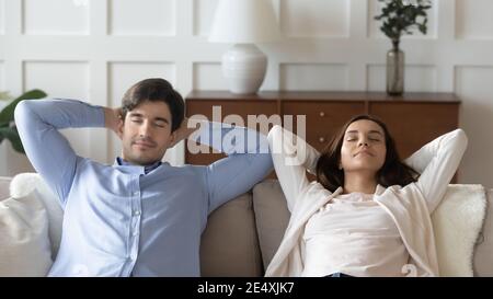 Gros plan jeune femme et homme se reposant sur un canapé ensemble Banque D'Images