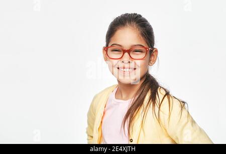 Enfant de race mixte souriant avec des lunettes élégantes, isolées sur fond gris clair. Correction de la vision pour les enfants Banque D'Images