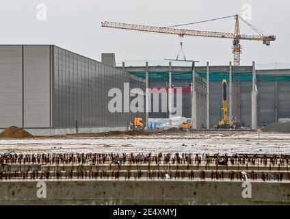 25 janvier 2021, Brandebourg, Grünheide: Le bâtiment de peinture (l) et d'autres bâtiments en construction sur le site de Tesla Gigafactory à l'est de Berlin. Un maximum de 500,000 véhicules par an doit sortir de la chaîne de production à l'usine à partir de juillet 2021 - le constructeur automobile prévoit d'atteindre le maximum le plus rapidement possible. Le constructeur automobile américain prévoit initialement d'employer jusqu'à 10,500 personnes par quart dans sa première usine prévue en Europe. Photo: Patrick Pleul/dpa-Zentralbild/ZB Banque D'Images