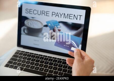 Gros plan femme tenant une carte de crédit en plastique, utilisant un ordinateur portable Banque D'Images