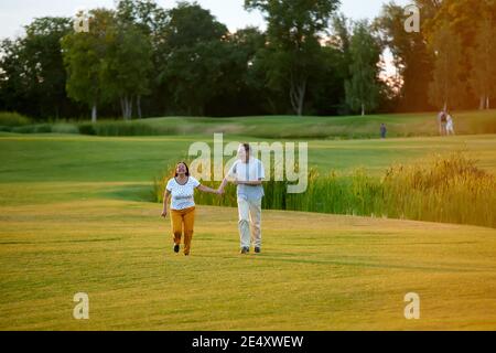 Un homme et une femme heureux qui s'exécutent sur le terrain. Banque D'Images