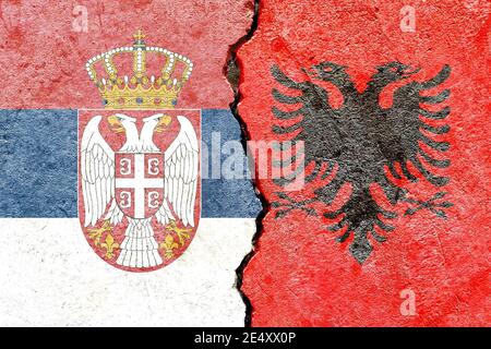 Drapeaux nationaux de la Serbie et de l'Albanie sur les brisures fissurées mur en béton Banque D'Images