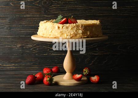 Stand avec gâteau Napoléon avec fraise sur fond de bois Banque D'Images