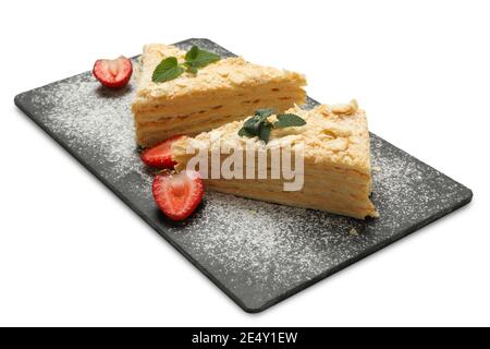 Planche avec des morceaux de gâteau Napoléon isolés sur fond blanc Banque D'Images