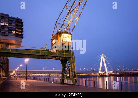 Vieille grue dans le port de Rheinau, en arrière-plan le pont Severins, Cologne, Allemagne. Alter Kran im Rheinauhafen, im hintergrund die Severinsbru Banque D'Images