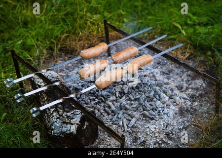 Saucisses frites sur brochettes. Soirées d'été près du feu, bon week-end Banque D'Images