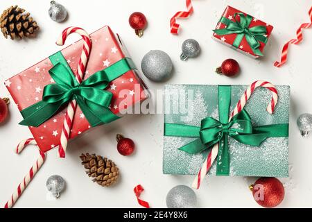 Boîtes cadeaux et accessoires de Noël soigneusement disposés sur un fond blanc, une composition lumineuse pour cadeaux de fêtes et ventes Banque D'Images