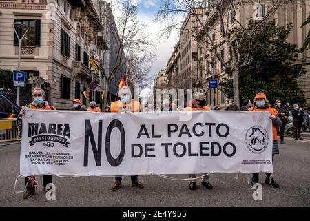 Barcelone, Espagne. 25 janvier 2021. Les manifestants portant des masques faciaux et des gilets de marée orange des retraités affichent une bannière pendant le rallye.la Marea Pensionista (le retraité Tide), une organisation qui rassemble les retraités, s'est réunie devant la délégation gouvernementale de l'Espagne à Barcelone pour défendre le droit aux pensions et exiger des services publics gratuits. Crédit : SOPA Images Limited/Alamy Live News Banque D'Images