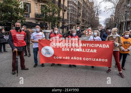 Barcelone, Espagne. 25 janvier 2021. Les manifestants qui portent des masques faciaux affichent une grande bannière pendant le rassemblement.la Marea Pensionista (le retraité Tide), une organisation qui rassemble les retraités, s'est réunie devant la délégation gouvernementale de l'Espagne à Barcelone pour défendre le droit aux pensions et exiger des services publics gratuits. Crédit : SOPA Images Limited/Alamy Live News Banque D'Images