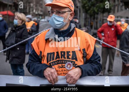 Barcelone, Espagne. 25 janvier 2021. Un manifestant est vu portant un masque et un gilet de marée de pensionné orange pendant le rallye.la Marea Pensionista (le pensionné Tide), une organisation qui rassemble les retraités, S'est réuni devant la délégation gouvernementale de l'Espagne à Barcelone pour défendre le droit aux pensions et exiger des services publics gratuits. Crédit : SOPA Images Limited/Alamy Live News Banque D'Images