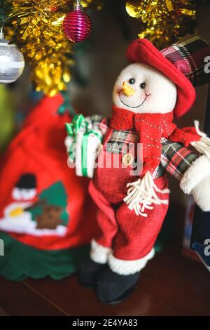 Le Père Noël bonhomme de neige avec des cadeaux sous l'arbre de Noël, saison de fête heureuse, bonhommes de neige heureux avec des cadeaux sur un arbre de noël Banque D'Images
