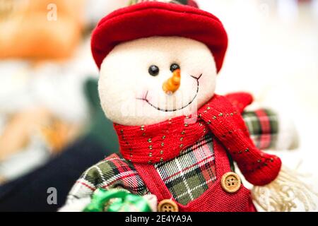 Gros plan d'un jouet bonhomme de neige, décoration de jouet pour la maison, cadeaux faits à la main, bonhomme de neige à faire soi-même, bonhomme de neige heureux dans un chapeau rouge et un foulard Banque D'Images