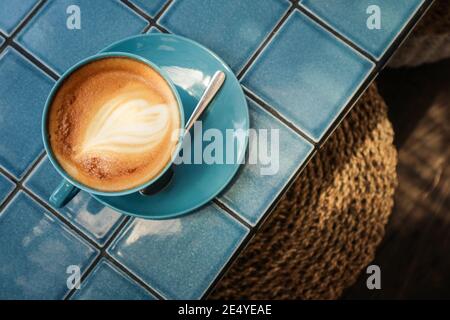 Café avec art latte sur le dessus dans la tasse bleue, vue de dessus Banque D'Images