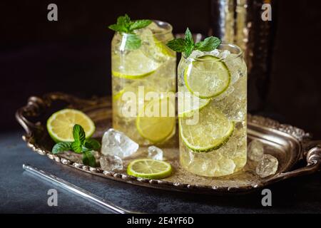 Boisson d'été thé vert glacé avec tranches de citron et menthe sur fond sombre Banque D'Images