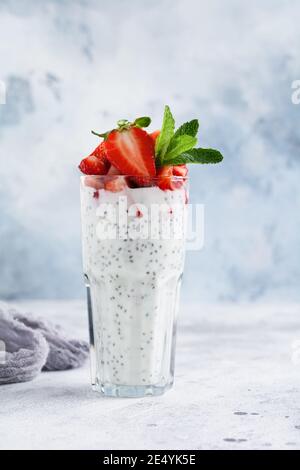 Des fraises à smoothie saines végétariennes, des graines de menthe et de chia sur fond de béton gris. Mise au point sélective. Espace pour le texte Banque D'Images