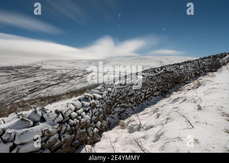 Swaledale vue par une pleine lune lumineuse pendant une nuit froide glaciale depuis le col des Butterbees, North Yorkshire, Royaume-Uni. Banque D'Images