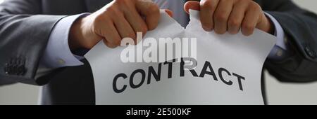 Les mains de sexe masculin déchirent le papier contractuel dans le bureau Banque D'Images