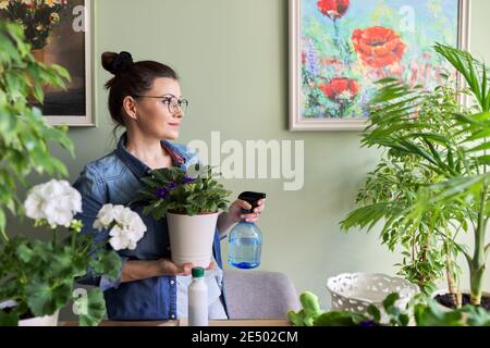 Femme s'occupant des plantes d'intérieur, des passe-temps et des loisirs, de la nature dans la maison Banque D'Images