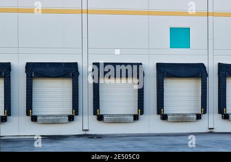 Portes de quai de chargement à l'arrière d'un entrepôt générique dans un quartier industriel. Banque D'Images