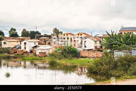 Antananarivo, Madagascar - 24 avril 2019: Groupe d'enfants malgaches inconnus debout devant leur maison, herbe et champs de riz inondés d'avant-grou Banque D'Images