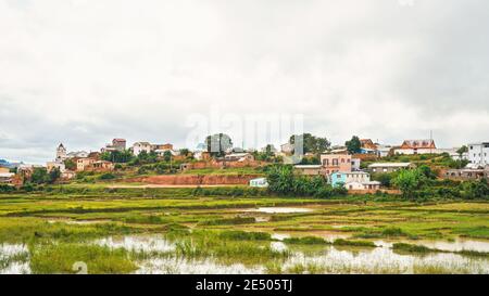 Antananarivo, Madagascar - 24 avril 2019: Paysage typique pendant une journée découverte près de la capitale de Madagascar, maisons sur de petites collines, avec des gens Banque D'Images