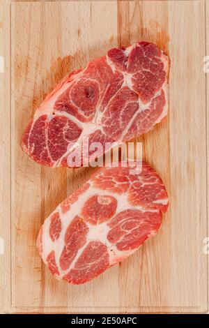 steak de porc marbré frais sur bois de hêtre massif planche à découper Banque D'Images