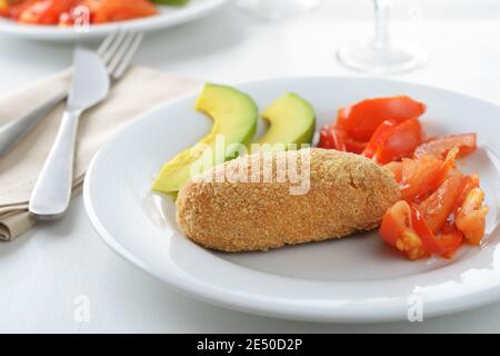 Patty de saumon cuite avec tranches de poivron rouge, de tomate et d'avocat Banque D'Images