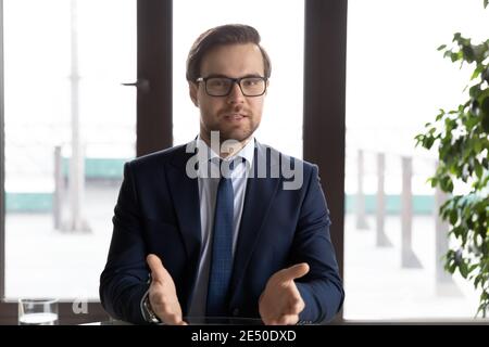 Portrait de tête homme d'affaires confiant portant des lunettes parlant à l'appareil photo Banque D'Images