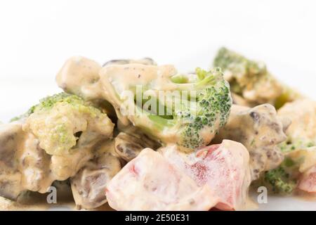 Viande compotée avec légumes dans une sauce à la crème aigre. Il y a un fond blanc pour un texte. Gros plan. Banque D'Images