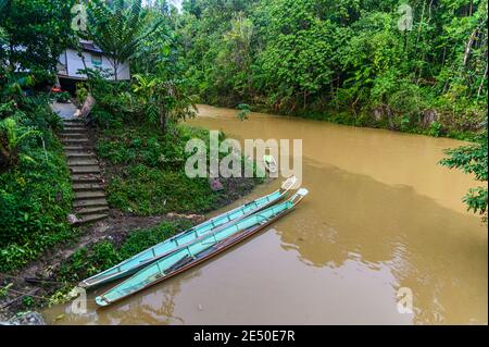 Longboats en bois se reposant près des maisons IBAN dans l'eau tannique Banque D'Images