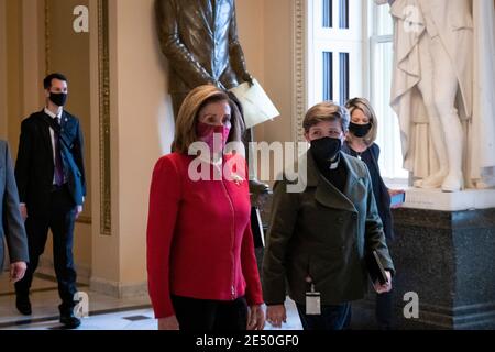 La Présidente de la Chambre des représentants des États-Unis Nancy Pelosi (démocrate de Californie), à gauche, marche avec l'aumônier de la Chambre des représentants Margaret Grun Kibben, à droite, de la Chambre à son bureau au Capitole des États-Unis à Washington, DC, le lundi 25 janvier 2021. Crédit : Rod Lamkey/CNP/MediaPunch Banque D'Images