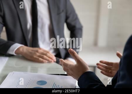 Des partenaires commerciaux en gros plan discutent des statistiques du projet lors de la réunion Banque D'Images