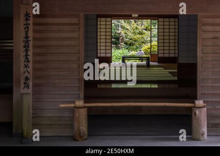 Gros plan d'un temple japonais traditionnel en bois, avec une porte menant dans un salon et dehors dans un jardin arrière Banque D'Images